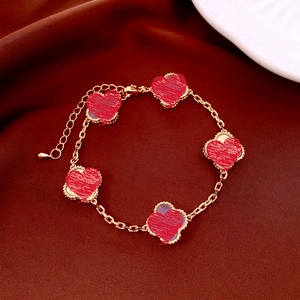 Vue détaillée du bracelet plaqué or 18k avec cinq trèfles rouges sur velours