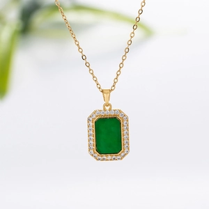 Detail of a green square pendant on a gold chain with white zircon stone accents