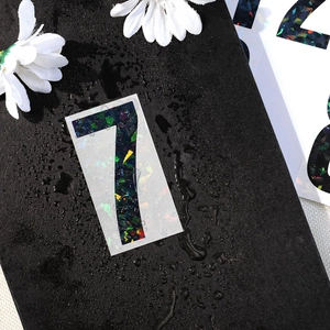 Macro detail of waterproof holographic number 7 sticker with shiny rainbow glitter texture