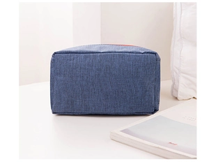 Close-up of blue linen texture multi-functional storage bag on a clean white desk surface