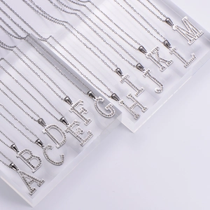 Silver letter necklace with rhinestones A to M displayed on acrylic stands