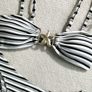 Close-up of black and white striped bikini top featuring a gold starfish connector