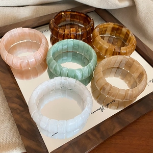 Detail view of colorful resin elastic bracelets with faux stone texture on mirror tray