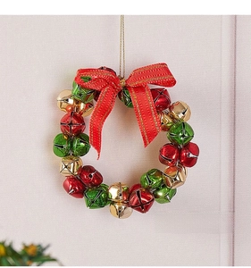 Close-up of a Christmas wreath made of red, green, and gold bells with a red silk bow