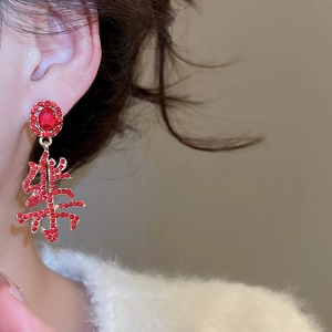 Macro view of Chinese character Joy earring featuring red rhinestones and silver needle