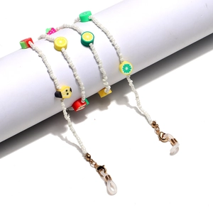 Close-up of white beaded eyewear chain with colorful polymer clay fruit charms and metal clasps