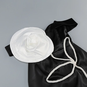 Détail de robe en satin avec fleur 3D surdimensionnée et finitions en perles blanches