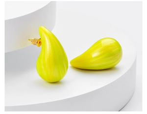 Detail of glossy yellow teardrop earrings on white circular display stands