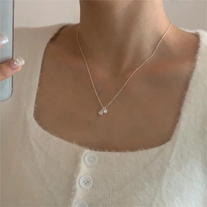 Macro shot of 925 sterling silver necklace with teardrop and round zircon pendant on model