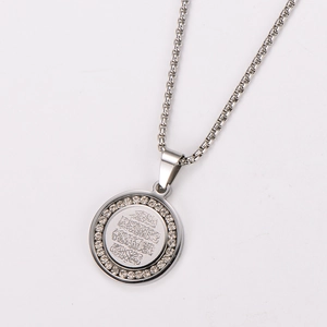 Macro detail of silver round pendant with Arabic calligraphy and crystal setting