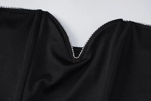 Close-up of elegant V-neckline with shimmering silver rhinestones on black fabric