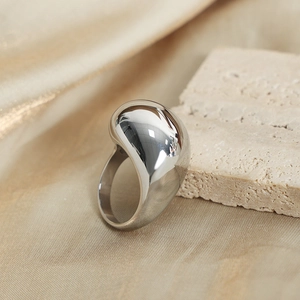 Minimalist silver teardrop ring with polished mirror finish on natural stone background