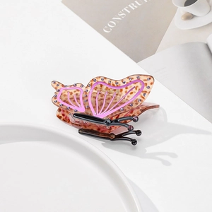 Macro shot of butterfly hair claw clip with leopard print and purple rhinestone edges
