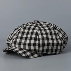 Detailed view of the vintage black and white plaid pattern on the linen newsboy cap fabric