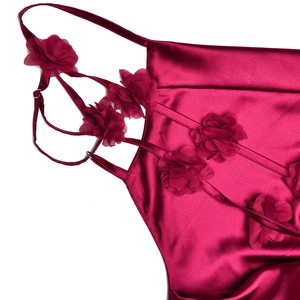 Détail d'une robe en satin bordeaux avec appliques florales et fines bretelles spaghetti