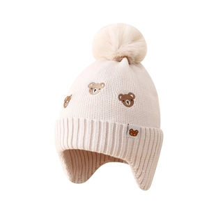 Cozy knit baby earflap hat in beige with bear embroidery and soft pom-pom detail