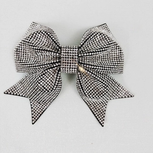 Detail shot of a large black bow hair clip with sparkling silver rhinestones
