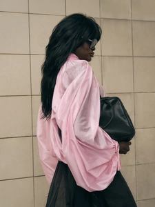 Pink high-neck puff sleeve blouse paired with a luxury black leather tote handbag
