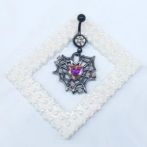 Detail of gothic spider web navel ring with heart stone and black plating finish