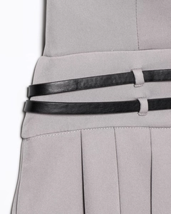 Detail of grey pleated dress featuring double black thin waist belts with buckles