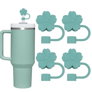 Detail of mint green cherry blossom silicone straw covers on a matching tumbler straw