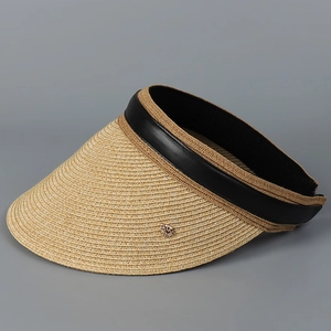 Detail of wide brim straw sun hat featuring black leather trim and golden metal buckle