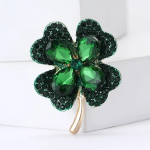 Elegant four-leaf clover brooch featuring green rhinestones on a gold metal base