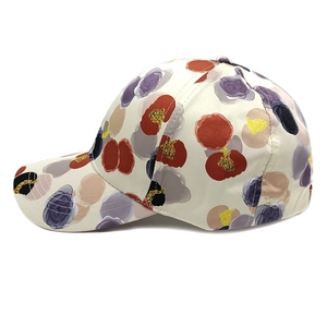Détail d'une casquette de baseball à fleurs avec imprimé rouge et paillettes dorées
