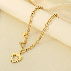 Détail du collier cœur doré avec chaîne en O, fermoir OT et pendentif cœur évidé