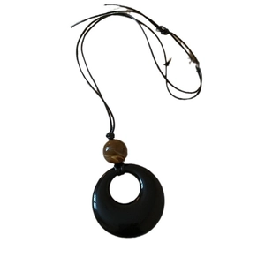 Retro minimalist necklace featuring a brown textured bead and black ring pendant