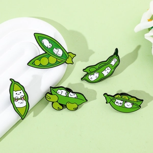 Detail view of five creative enamel pins featuring white cats inside green pea pods