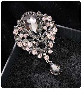 Macro shot of vintage silver brooch with gray teardrop crystal and sparkling rhinestones
