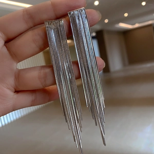 Nahaufnahme eleganter langer Silber-Quastenohrringe mit zarten metallischen Kettensträngen