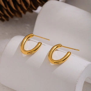 Minimalist U-shaped 18K gold plated stainless steel earrings on a white display stand