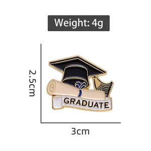 Graduation cap enamel pin with certificate scroll and white banner on gold alloy