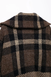 Detail of wool-like plaid bomber jacket showing collar texture and brown check fabric