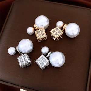 Close-up of pearl and cubic zirconia square pendant earrings in gold and silver finish