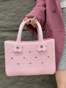Dettaglio della borsa in EVA rosa con trama geometrica a rombi e rivetti a forma di fiore