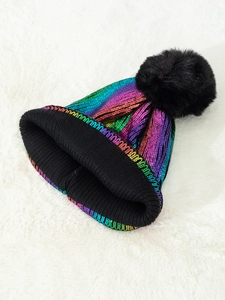 Close-up of metallic rainbow knit beanie with black pom-pom and ribbed cuff detail