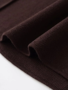 Dettaglio macro della trama in maglia marrone scuro di alta qualità e tessuto morbido