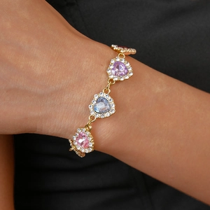 Détail du bracelet en or en forme de cœur avec gemmes colorées et cristaux brillants