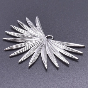Detailed macro view of silver leaf-shaped jewelry pendant with delicate textures