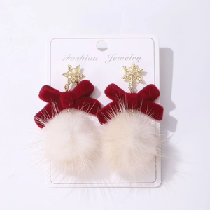 Detail of Christmas earrings featuring gold snowflakes, red velvet bows and white fur balls