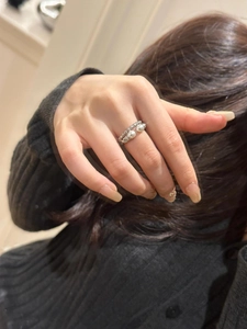 Detail of S925 silver twisted ring featuring double pearls and shimmering gemstones