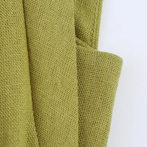 Detailed macro view of olive green linen texture on an elegant sleeveless dress