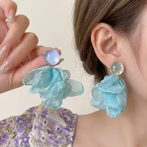 Detail of mint green silk petal earrings with shimmering iridescent stud on a model