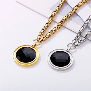 Detailed view of gold and silver chunky square chains with round black faceted stones
