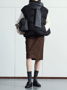 Brown suede midi skirt with slit detail styled with a winter vest and knit scarf
