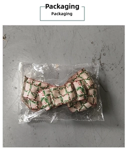 Macro detail of a burlap Christmas bow with pine and berry patterns in polybag packaging