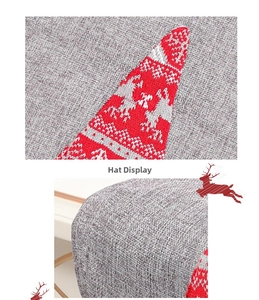 Detail of grey knitted Christmas hat featuring red and white reindeer patterns and stitching